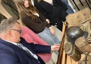 Pan dyrektor wraz z uczniami oglądają eksponaty
