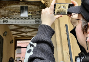 Uczennica fotografująca detal architektoniczny kamienicy przy ulicy Piotrkowskiej 86