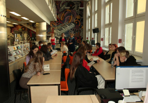 Uczniowie klasy 1UA podczas zajęć w bibliotece słuchają wykładu.