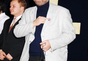 Wojciech Bonowicz przypina tarczę liceum